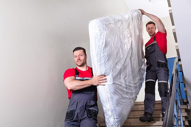 two workers lifting a box spring out of a bedroom in Elverta, CA